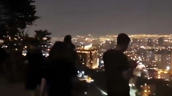 伊朗民众聚在山上看防空系统拦攻击